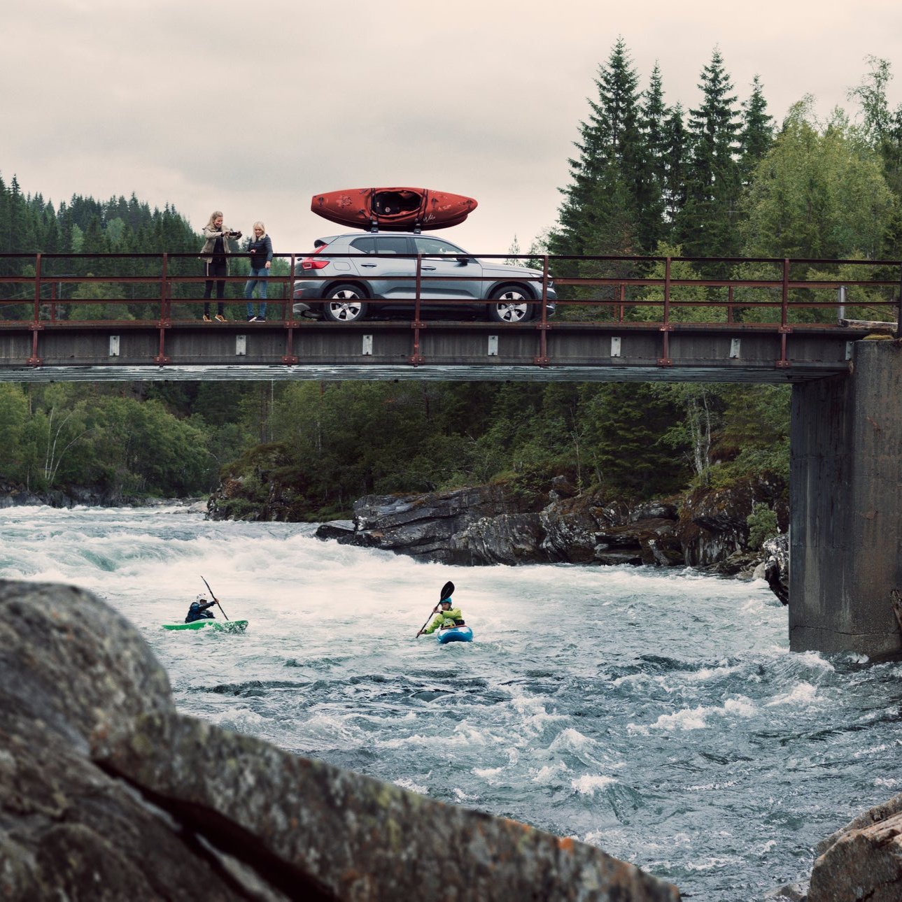 Car with boats above a river