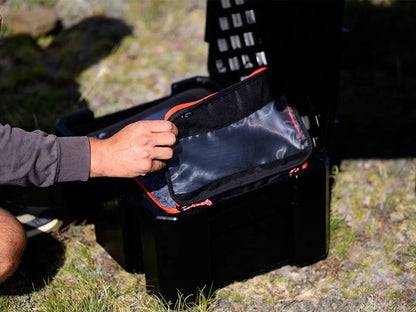 Person opening a black tool box with transparent pouches outdoors